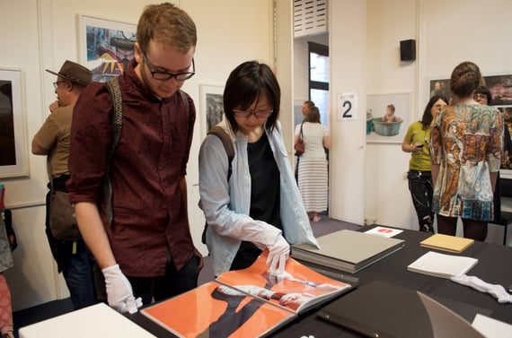 Students and guests looking at photobooks at PSC's End of the Year Exhibition